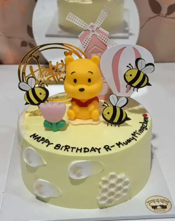 เค้กหมีพูห์น่ารักพร้อมผึ้งและผลไม้สดบนเค้กสำหรับวันเกิด.