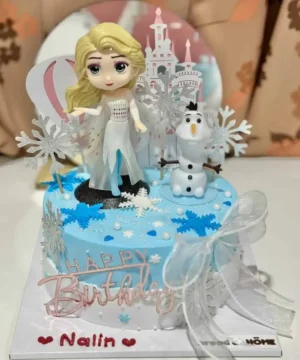 เทียนเค้กวันเกิดเจ้าหญิงและนกนางนวลในธีมฤดูหนาวบนเค้กสีฟ้า พร้อมของตกแต่งคริสต์มาสและคำอวยพรวันเกิดสำหรับเด็กสาว.