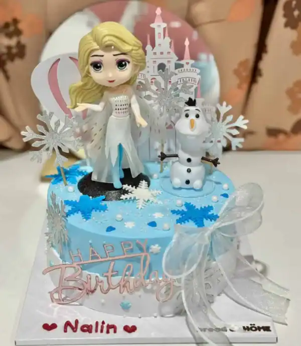 เทียนเค้กวันเกิดเจ้าหญิงและนกนางนวลในธีมฤดูหนาวบนเค้กสีฟ้า พร้อมของตกแต่งคริสต์มาสและคำอวยพรวันเกิดสำหรับเด็กสาว.