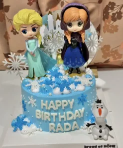 เค้กน้ำแข็งเจ้าหญิงเอลซ่าและอันนาสีฟ้าสดใส พร้อมตกแต่งด้วยหิมะเทียมและตัวการ์ตูนจากภาพยนตร์ดัง.