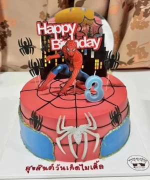 เค้กสไปเดอร์แมนหลากสีสันบนโต๊ะ พร้อมการตกแต่งด้วยแมงมุมและคาแรคเตอร์ Spiderman สำหรับงานวันเกิดเด็กอายุ 3 ปี.