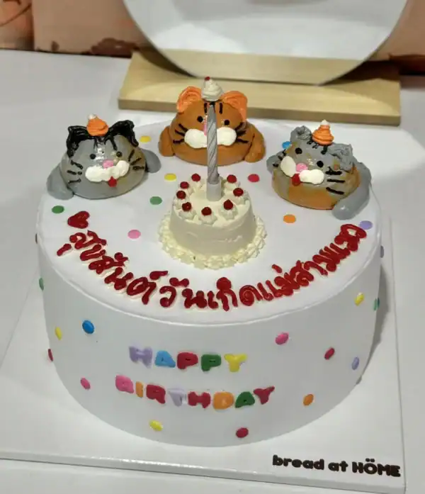 เค้กแมวสุดน่ารักพร้อมเทียนและตกแต่งด้วยแมวเหมียวครีเอทีฟ เหมาะสำหรับฉลองวันเกิดแมวหรือเป็นของขวัญสุดพิเศษสำหรับคนรักแมว.