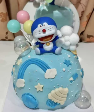 ครีเอทีฟเค้กวันเกิดการ์ตูนโดราเอม่อนสีฟ้ากับองค์ประกอบฝันร้ายและลูกโป่งสดใสสำหรับงานเลี้ยงเด็ก.