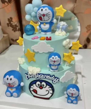 เค้กโดเรมอนสีฟ้าสดใสพร้อมตกแต่งด้วยดาวและเมฆน่ารัก เหมาะสำหรับฉลองวันเกิดหรือโอกาสพิเศษของแฟนคลับโดเรมอนทุกวัย.