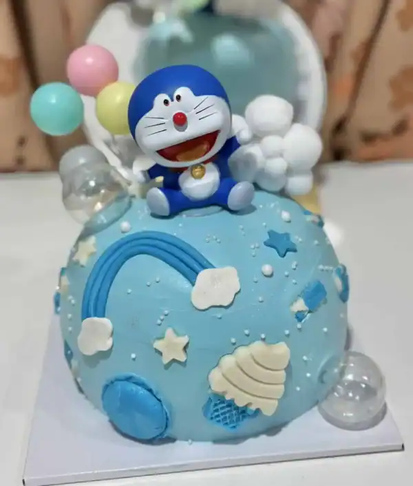 ดอกไม้เค้กสีฟ้าพร้อมตัวการ์ตูนโดราเอม่อนชื่อดังบนยอดเค้กที่ตกแต่งด้วยดาวและเมฆสีขาวสำหรับงานเลี้ยงวันเกิด.