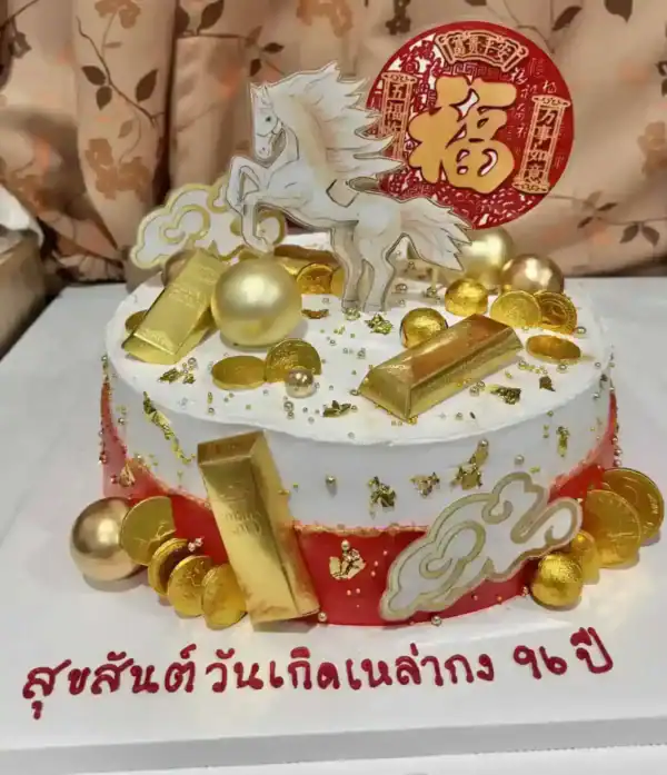 เค้กวันเกิดมงคลทองคำ พร้อมม้าเทพเจ้าและสัญลักษณ์โชคลาภทองคำ สื่อถึงความมั่งคั่งและโชคดีตลอดปี.