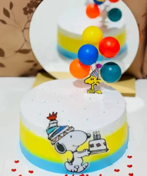 เค้กวันเกิด Snoopy และเพื่อน ๆ พร้อมลูกโป่งสีสันสดใส สำหรับฉลองโอกาสพิเศษด้วยภาพถ่ายอาหารและขนมหวาน.