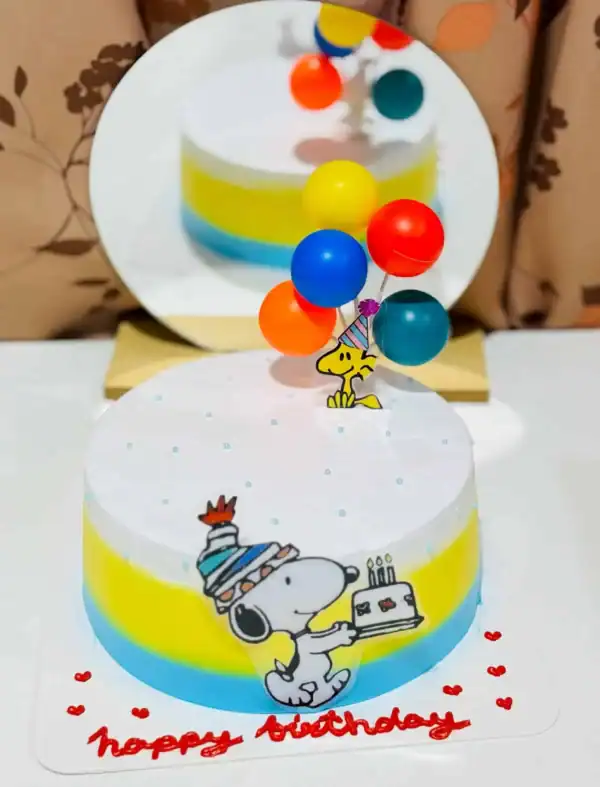 แถบคำอธิบายภาพ: เค้กวันเกิดสีสันสดใสพร้อมภาพวินนิพิกแสนสนุกและลูกโป่งสำหรับฉลองวันเกิดเด็ก.