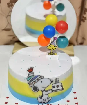 ขนมเค้กวันเกิด Snoopy กับลูกโป่งสีสันสดใสสำหรับงานเลี้ยงวันเกิด, สร้างบรรยากาศสนุกสนานและเปลี่ยนแปลงในงานฉลองที่บ้าน, สัญลักษณ์แห่งความสุขและความสนุกในโอกาสพิเศษ.