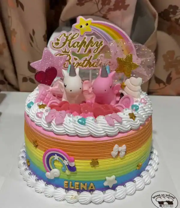 เทียนเค้กยูนิคอร์นสีชมพูและสายรุ้ง พร้อมตกแต่งด้วยลูกโป่งหัวใจและดาว สร้างความสุขในวันเกิดสำหรับเด็กผู้หญิงในบรรยากาศอบอุ่นและน่ารัก.
