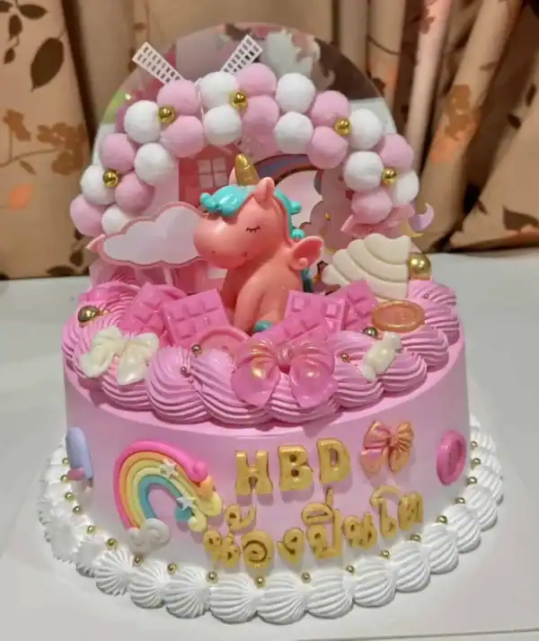 เทียนเค้กยูนิคอร์นหวานสีชมพูและฟ้ายิ่งใหญ่พร้อมรายละเอียดน่ารักเหมาะสำหรับงานฉลองวันเกิดเด็กผู้หญิง, เค้กหน้างานเลี้ยงวันเกิดสำหรับเด็ก, ดีไซน์น่ารักและเต็มไปด้วยความสุข.