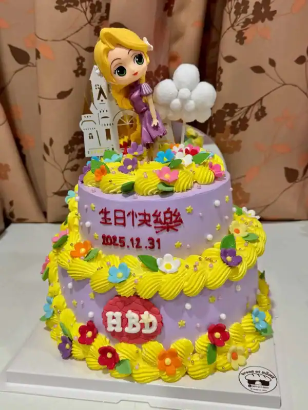 ลูกเค้กวันเกิดสีพาสเทลสดใส ประกอบด้วยดอกไม้ตกแต่งด้วยครีมและฟองน้ำฟู พร้อมตัวการ์ตูนเจ้าหญิงน่ารักบนยอดเค้ก.