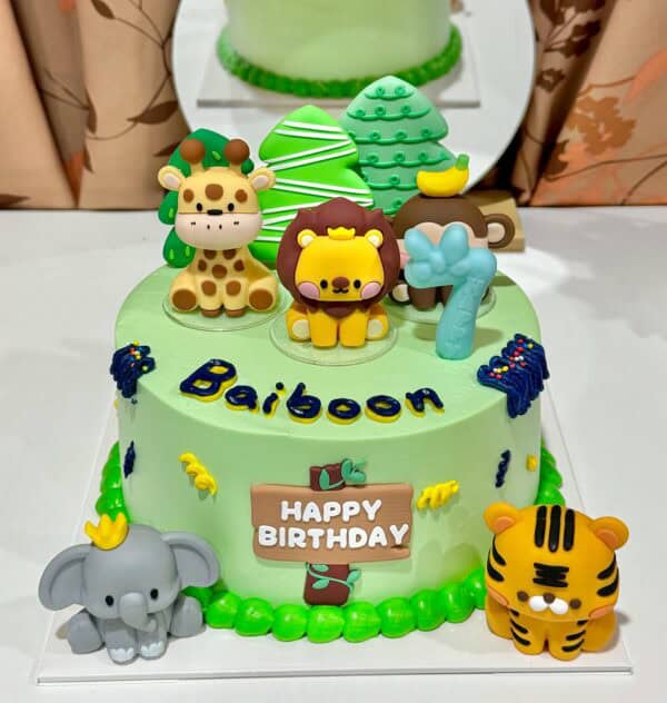 ก้อนเค้กวันเกิดลายแฟนซีสัตว์น่ารักพร้อมเทียนและคำอวยพรในธีมป่าไม้และสัตว์ป่าเหมาะสำหรับฉลองวันเกิดเด็กและความสุขในครอบครัว.