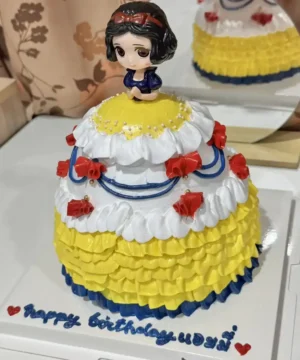 เค้กสโนไวท์หวานละมุน พร้อมตกแต่งด้วยครีมและลูกกวาดสีสดใส.