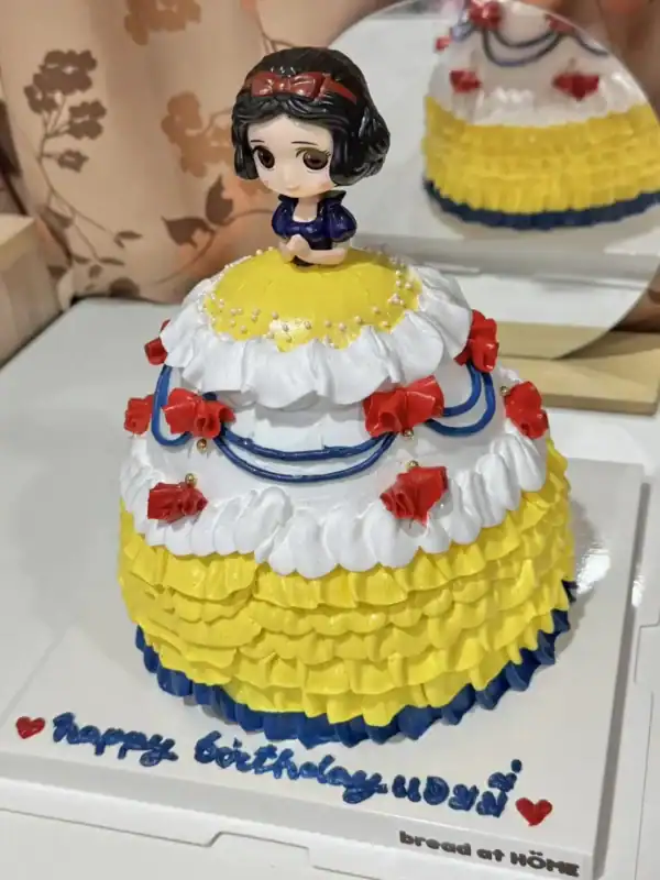 เค้กสโนไวท์หวานละมุน พร้อมตกแต่งด้วยครีมและลูกกวาดสีสดใส.